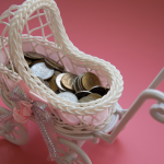 White baby carriage with coins in it