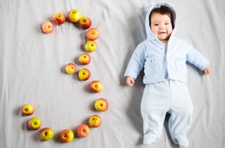 A young baby with the number three spelled out in apples. Assisted Reproductive Technology Law